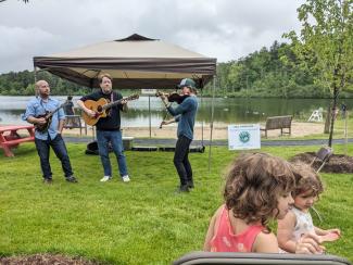  the bluegrass trio of GBLC board member Kate Roblin on fiddle, Sam Clement on guitar, and Dave Lawlor on mandolin entertained a modest but enthusiastic crowd, though the musicians opted for an unamplified, acoustic set due to a threat of lightning. 